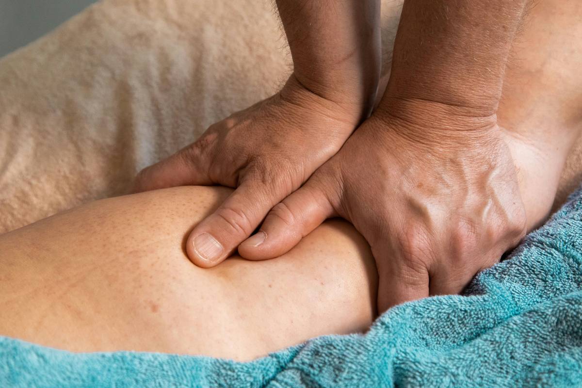Woman applying moisturizer after using a foot mask with routine foot care insurance label visible