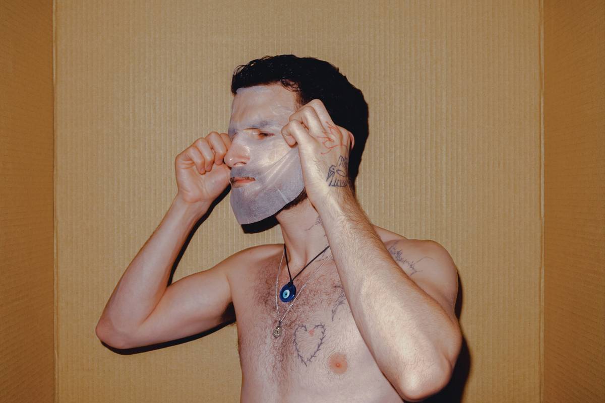 Woman applying facial masks for aging skin with calm expression, showing hydrated, glowing complexion